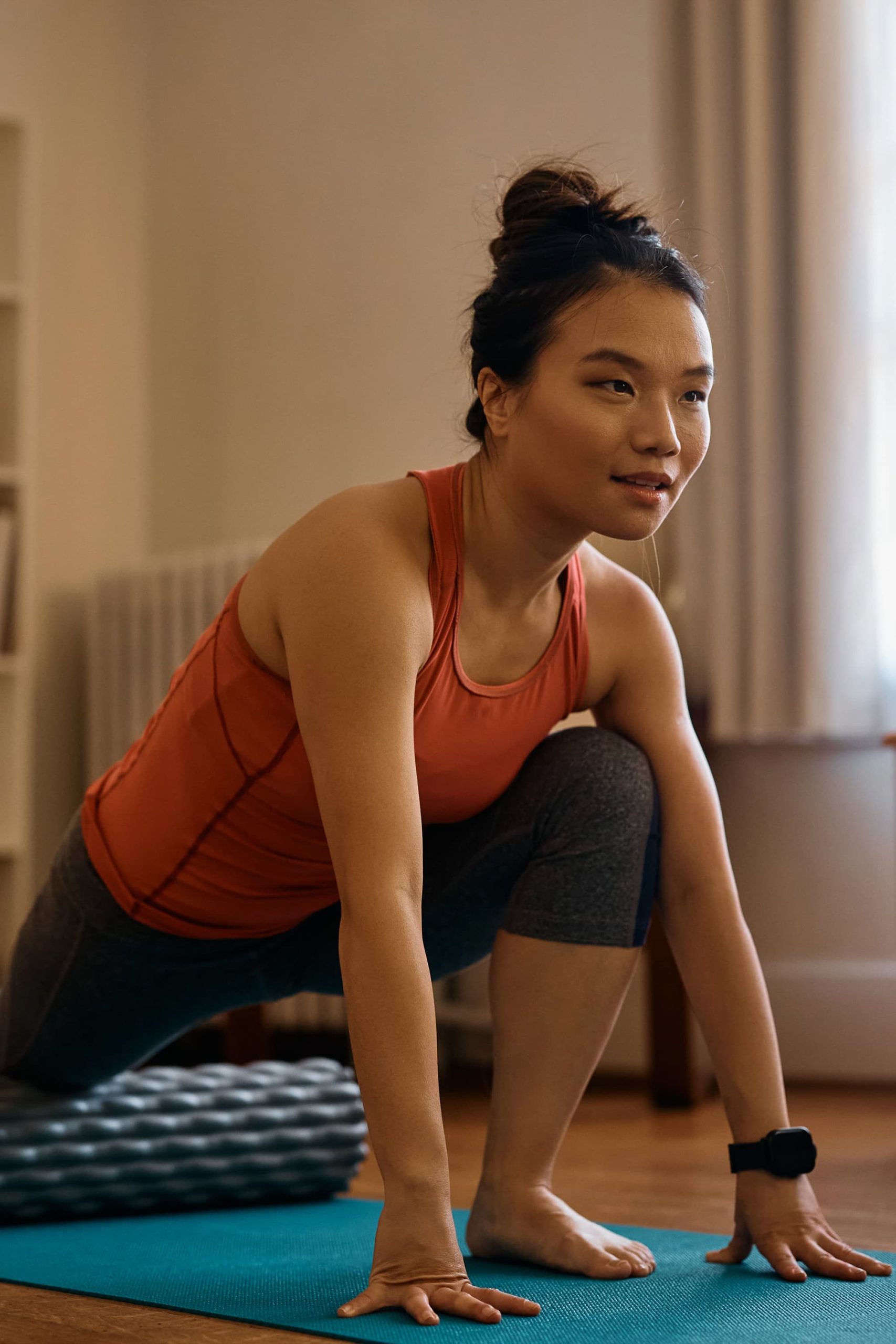 Asian woman learning how to use the foam roller.